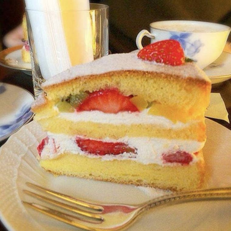 季節のフルーツと生クリームを挟んだ、黄色いスポンジ生地が美しいケーキ