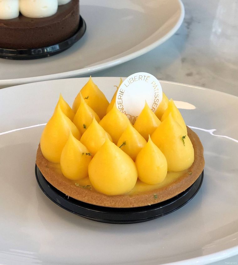 ツンツンとした絞りが特徴のレモンタルトが白いお皿に盛り付けられている様子