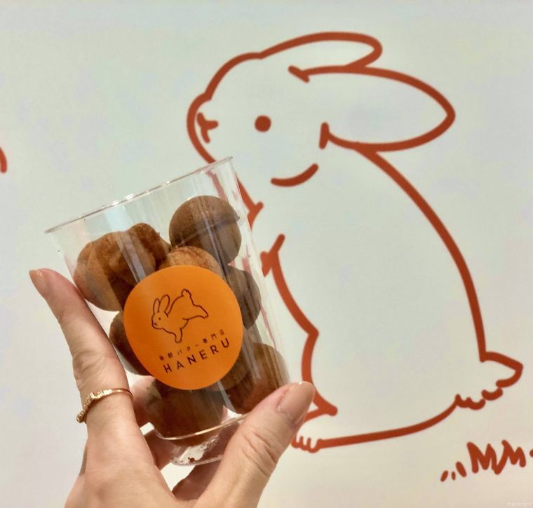 バックにウサギの絵の壁とカップに入った丸いカステラ