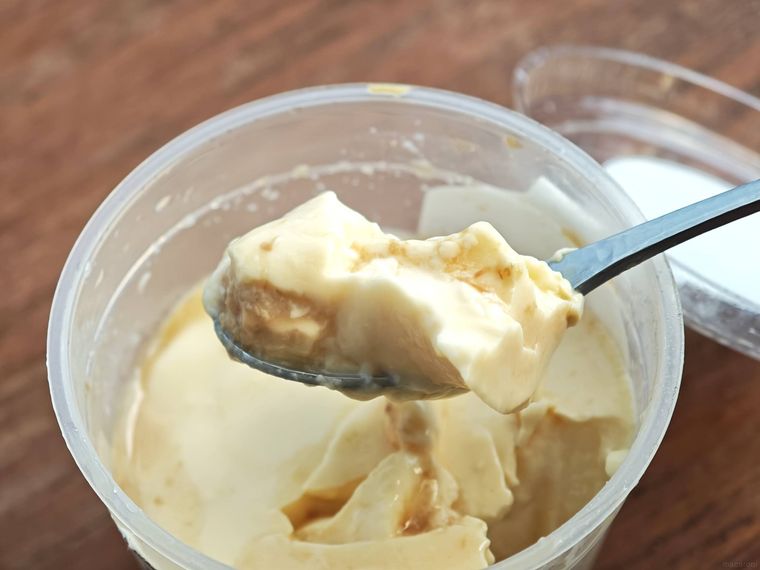 ファミリーマート窯出しとろけるプリンをスプーンですくう様子