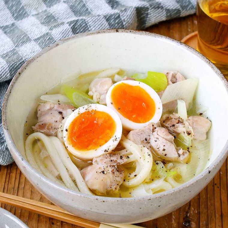 白い椀に盛り付けられた鶏もも肉と長ねぎのうま塩うどん