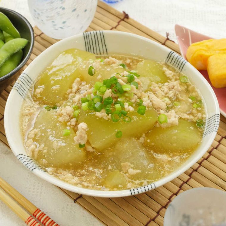 青い線模様が入った白い器に盛られた冬瓜と万能ねぎと鶏そぼろのあんかけ