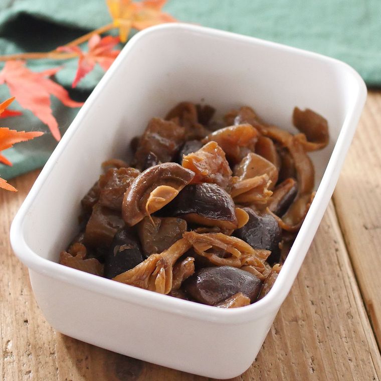 白い保存容器に盛られた、こんにゃくときのこの甘辛煮