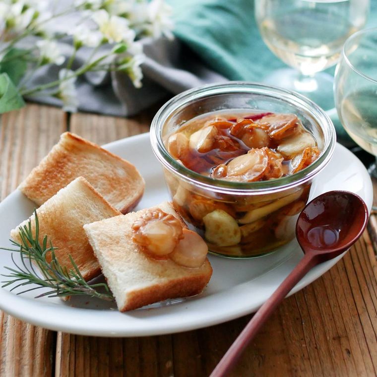 ガラス瓶に詰められ、トーストを添えたホタテときのこのオイル漬け