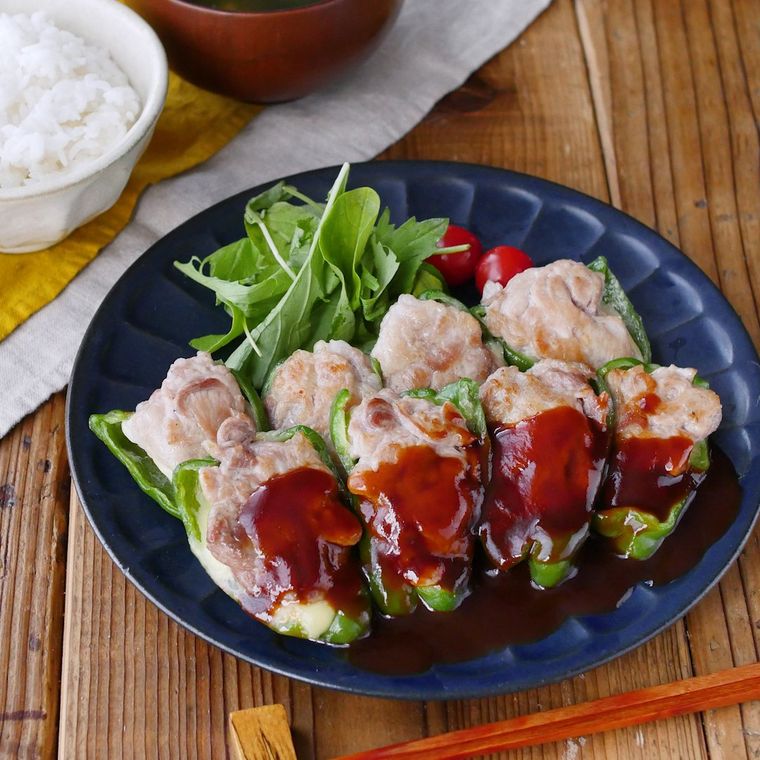 黒い皿に盛り付けられた、豚こまピーマンの肉詰め