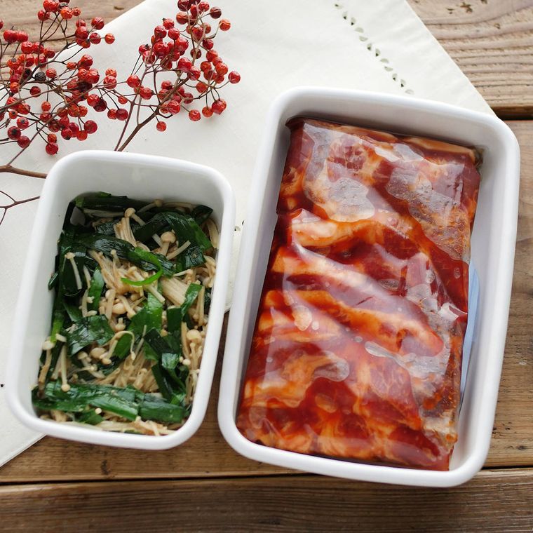 白い容器に入った豚肩ロースの焼肉とニラナムル