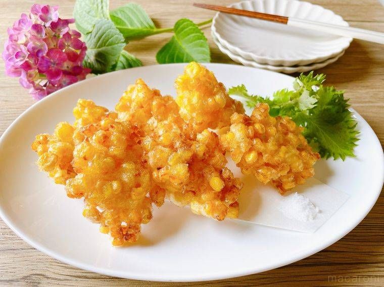楕円の白色の皿に盛られたとうもろこしのかき揚げ