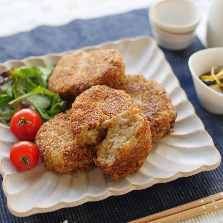 四角い器に盛り付けた肉みそのねっとり里芋コロッケ、ミニトマトとベビーリーフ