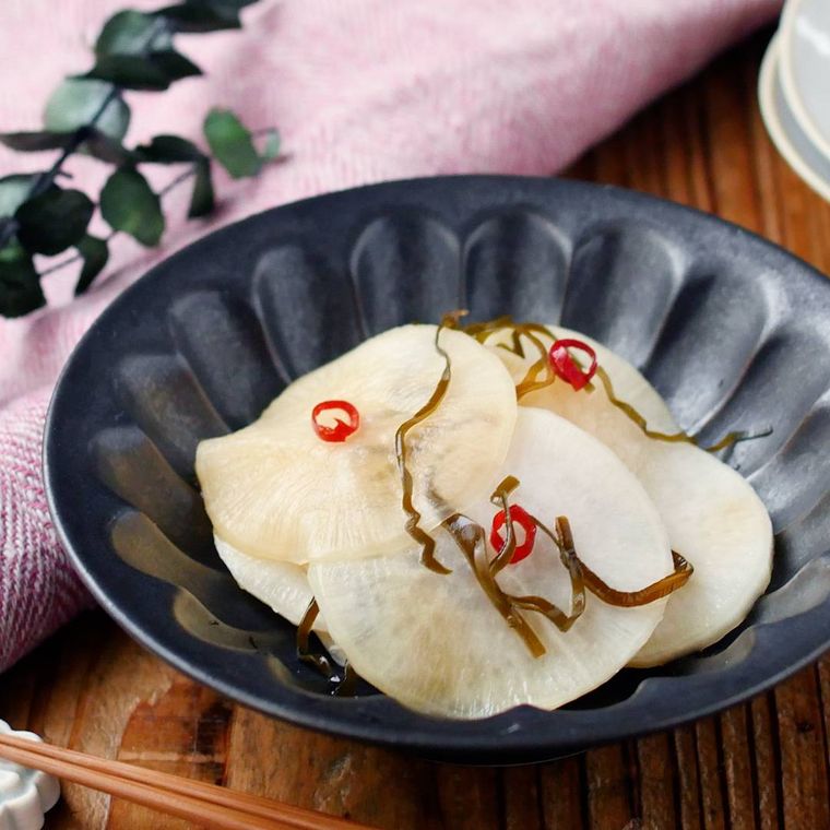 黒い小鉢に盛りつけられた大根の甘酢塩こんぶ漬け