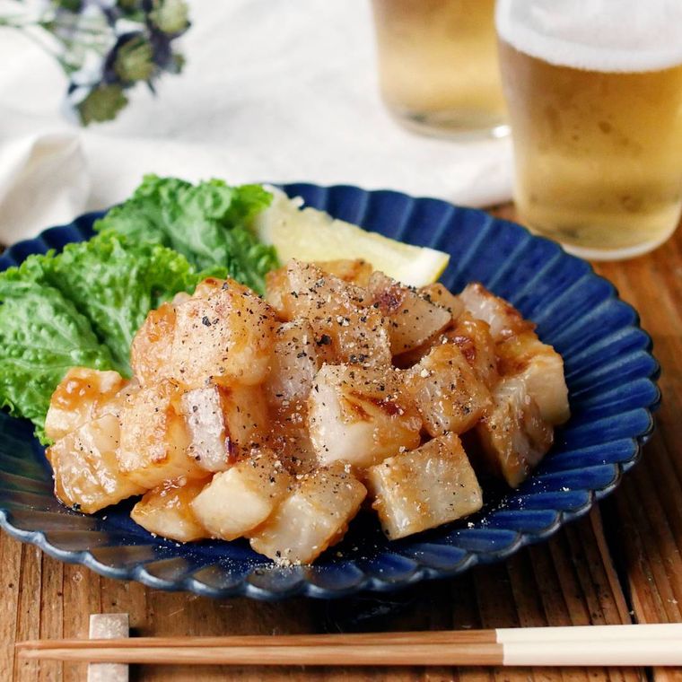 藍色の皿に盛りつけられた大根のサイコロステーキとつけ合わせ