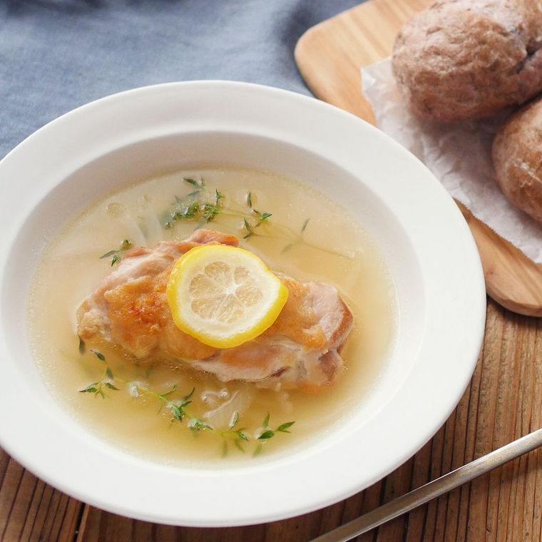 白い皿に入った鶏肉のレモンマリネスープ
