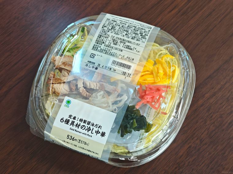 机の上にファミリーマートの定番特製醤油だれ6種具材の冷し中華が置いてある