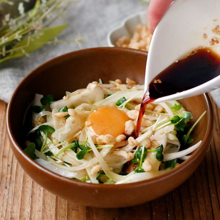 茶色い器に盛り付けたポン酢しょうゆの中華ドレッシングがけの新玉ねぎサラダ