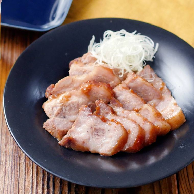 黒色の皿に盛りつけられた豚肩ロース肉のみそチャーシュー