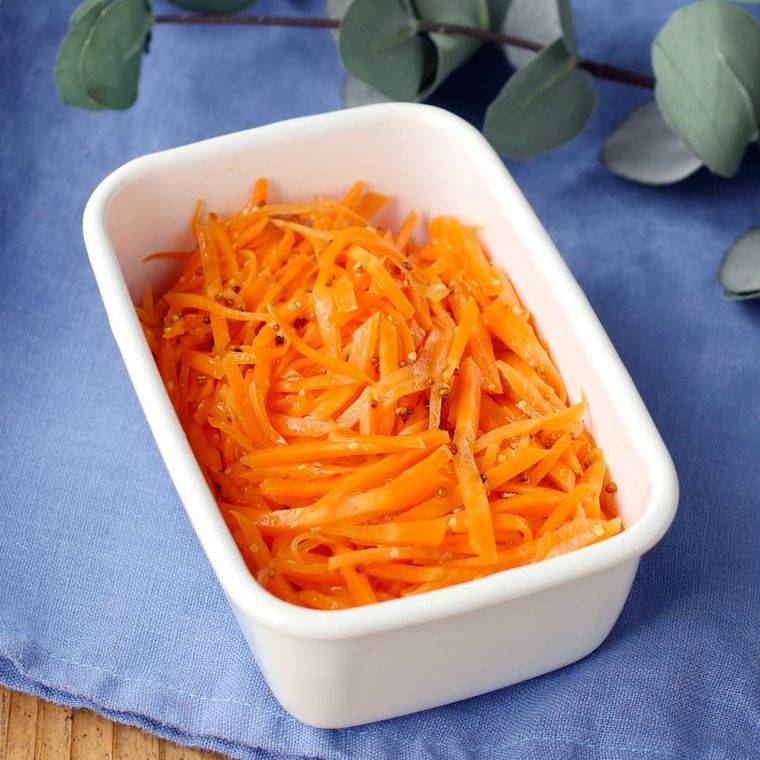 白い保存容器に入っているにんじんのマスタード風味マリネ