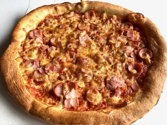 ウィンナーとベーコンがたっぷりのったピザ