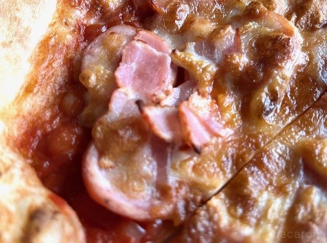 ジューシーなベーコンとウィンナーがトッピングされてるピザ