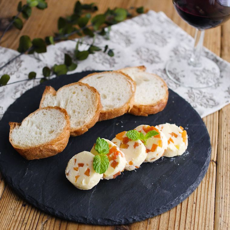 黒い皿に盛り付けたフランスパンとラム酒入り大人の干し柿バター