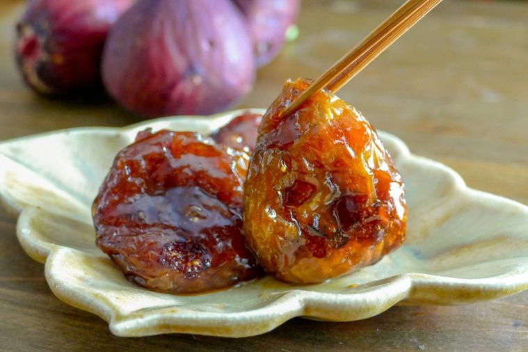 竹串でつまんで持ち上げたいちじくの甘露煮
