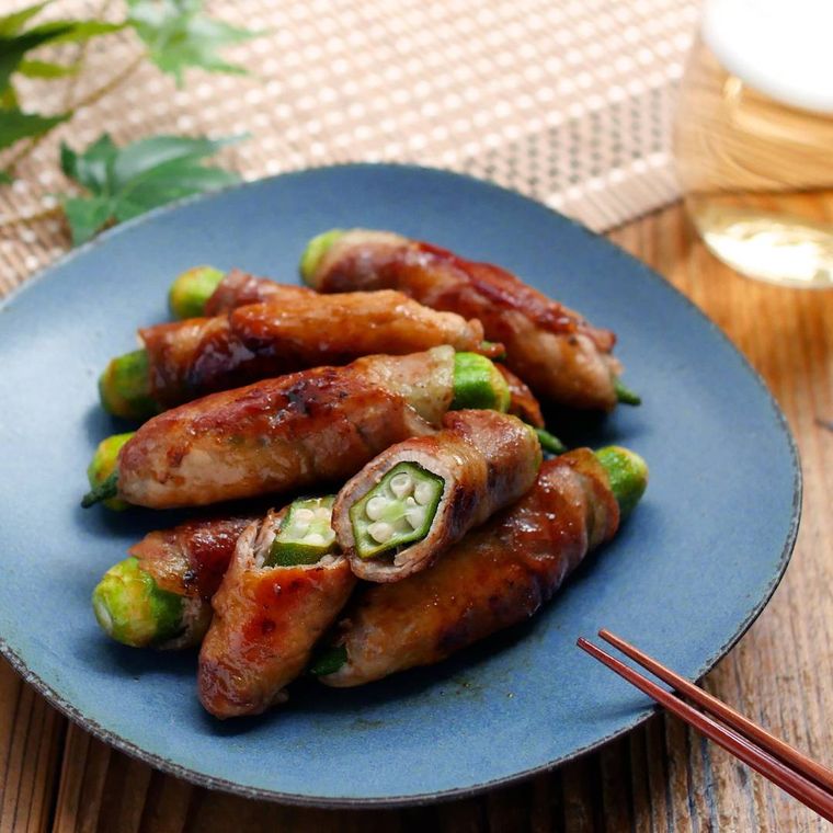青い皿に盛られたオクラの豚肉巻き