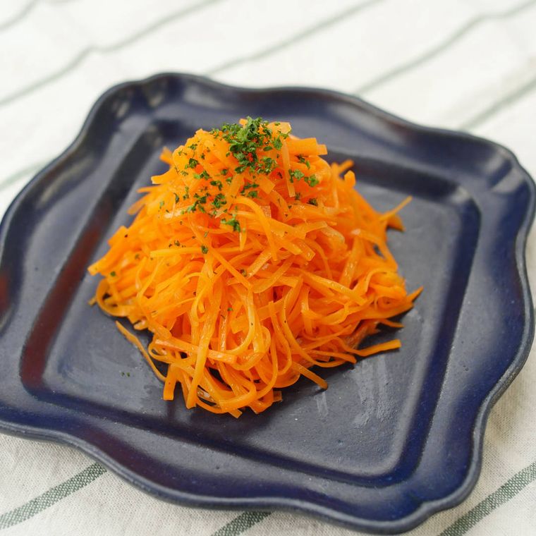 黒色のレースプレートに盛りつけられているキャロットラペ