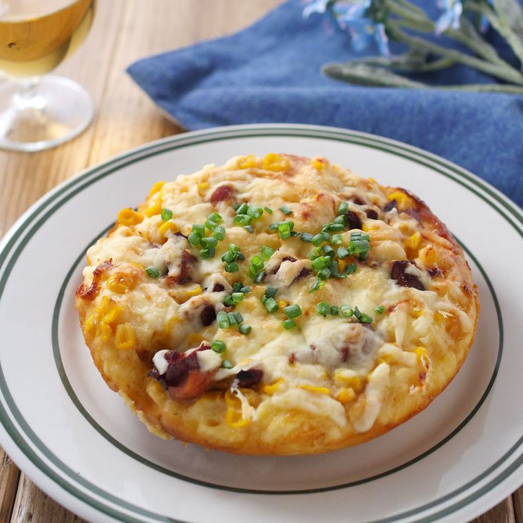 縁取りのある皿に盛りつけられている照り焼きチキンピザ