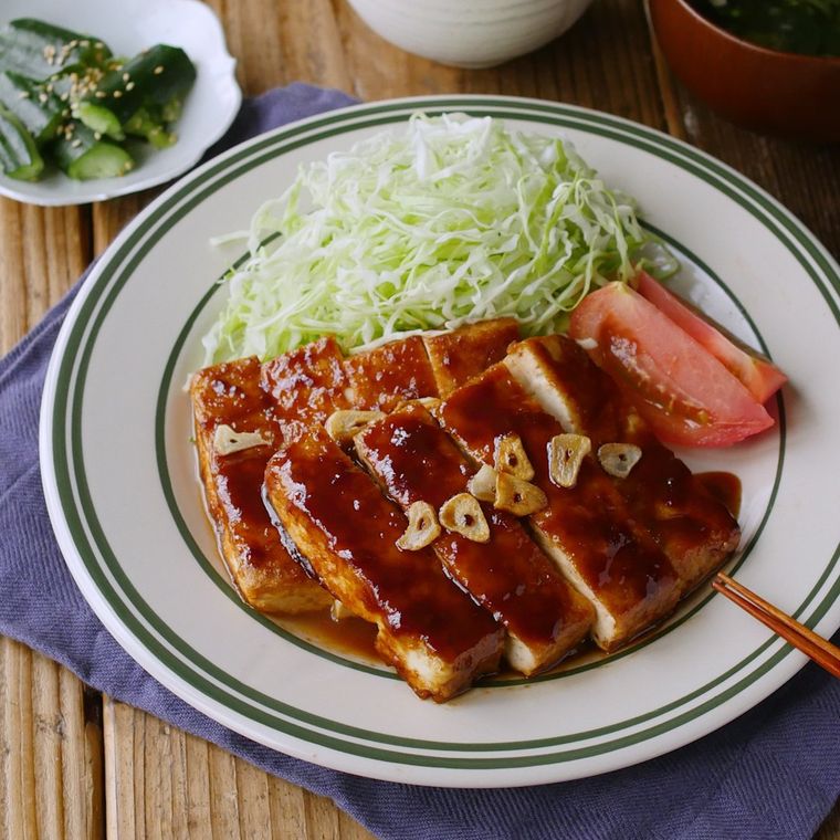 丸い皿に盛り付けられたトンテキ風豆腐ステーキ