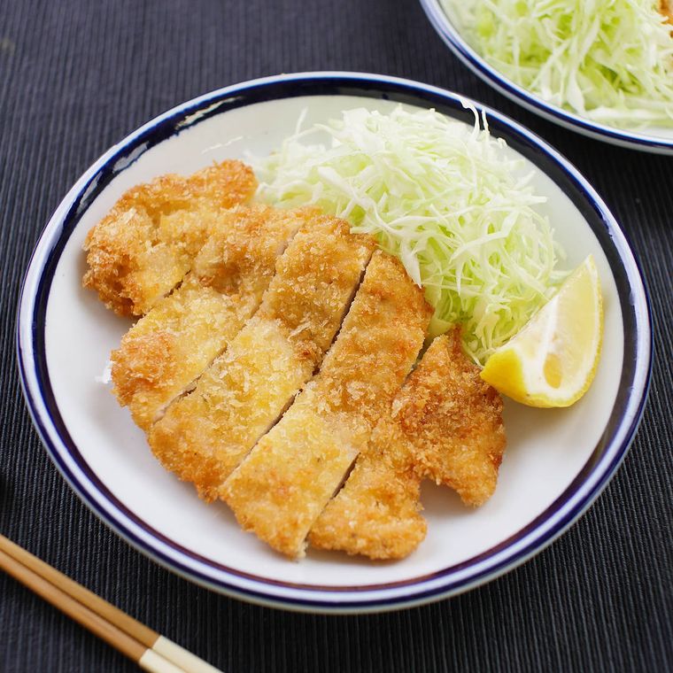 青い縁取りの皿に盛り付けられたチキンカツ