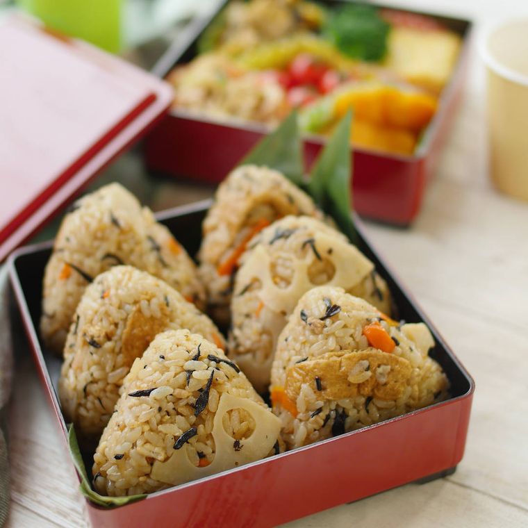弁当箱に入った油揚げとれんこんのいなり炊き込みごはんのおにぎり