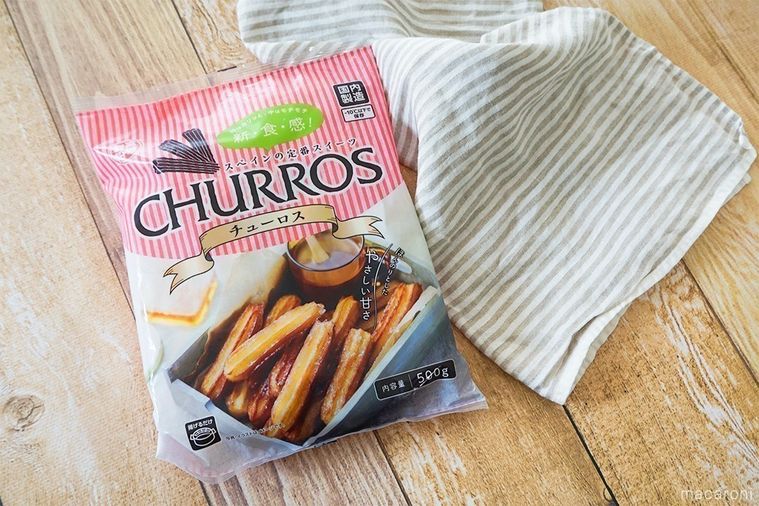 業務スーパーの冷凍チュロスのパッケージと縞模様の布を並べた様子