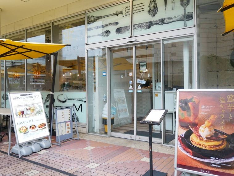 黄色いパラソルのテラス席があるパンケーキ店の外観