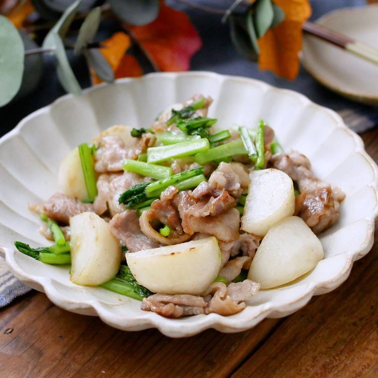 白い花型の皿に盛りつけられた豚バラとカブの旨塩炒め