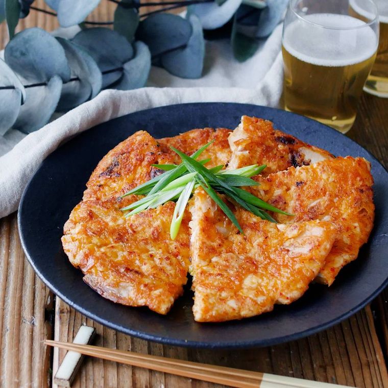 黒い皿に盛られた鶏むね肉のキムチーズ大判チヂミ