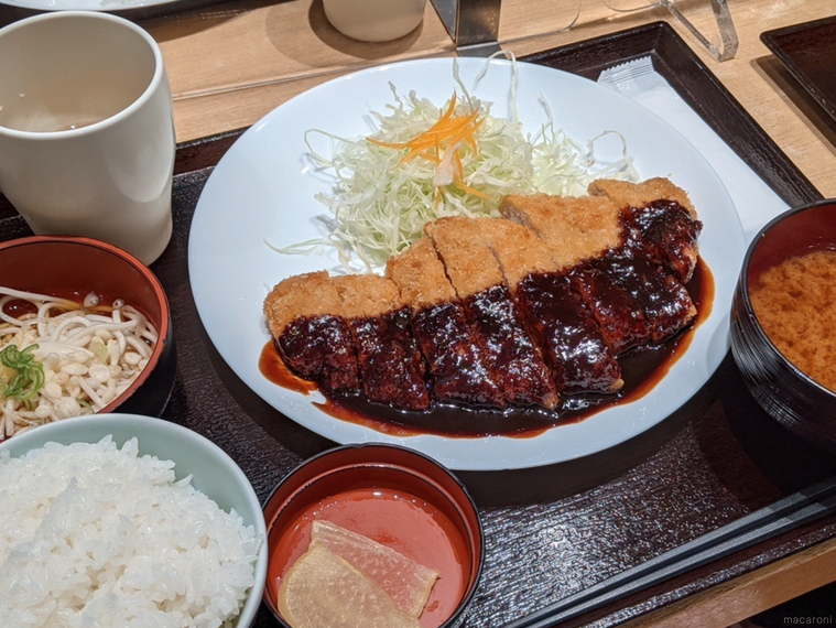 白いお皿にのった味噌カツとキャベツ、小皿の漬物、ごはん、うどん