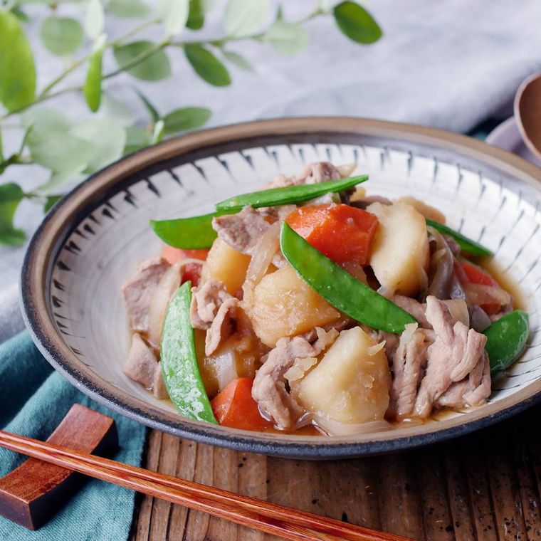 丸皿に盛り付けられた豚肉で作る肉じゃが