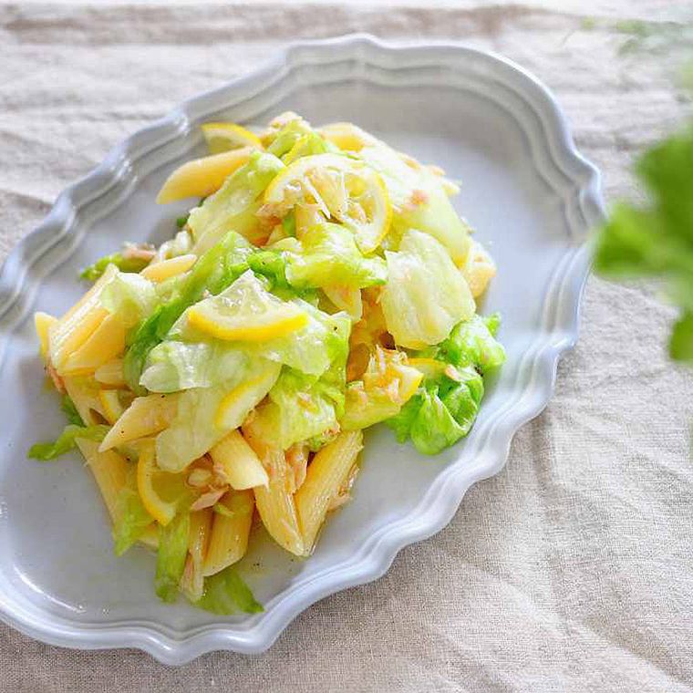 縁取りのある皿に盛りつけられたレタスとレモンのサラダペンネ