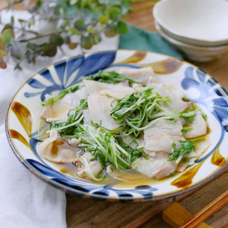 青と茶のリーフ柄の皿に盛られた豚肉と水菜の旨煮
