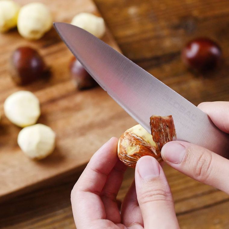 包丁で栗の渋皮を剥いている様子