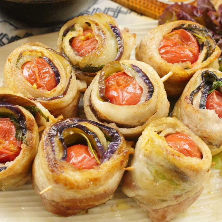 白い皿に盛られた豚バラなすの肉巻きミニトマト