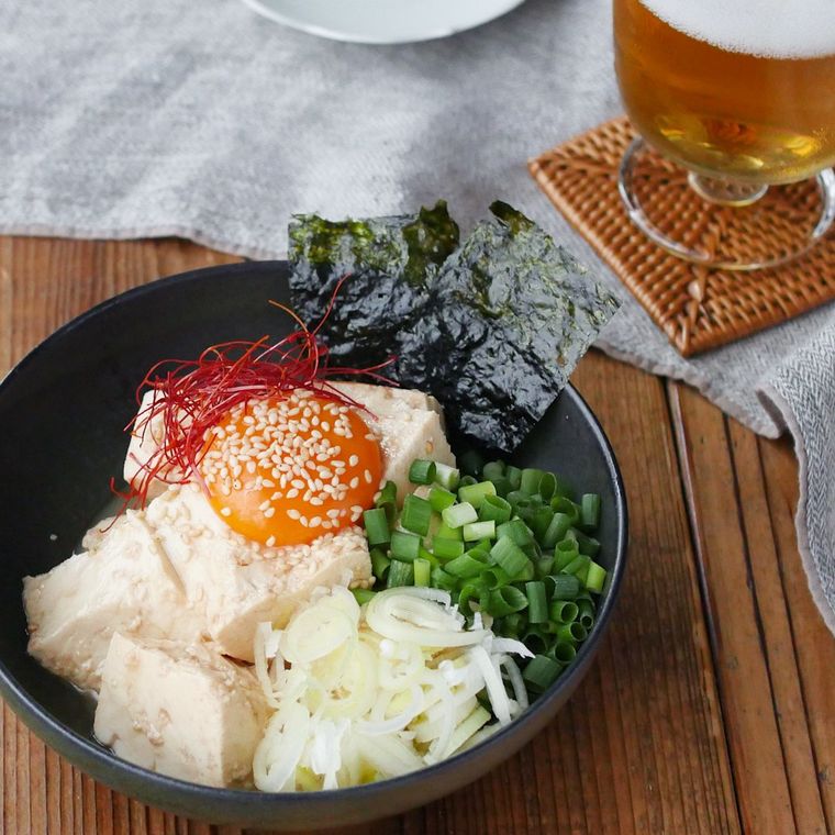 黒いボウルに盛りつけられている薬味たっぷりの油そば風冷や奴