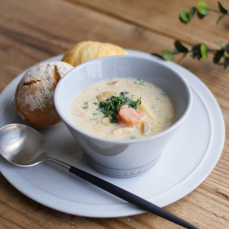 白い皿に盛りつけられたかぶの明太子クリームスープとパン