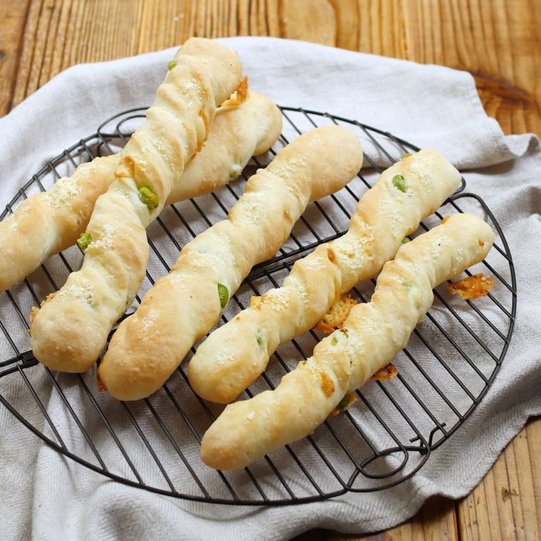 黒い網の上の置かれた枝豆チーズバトン