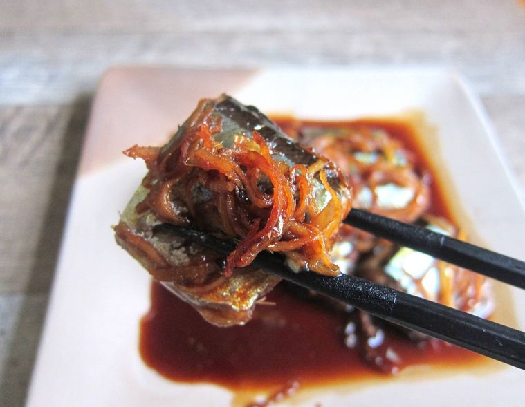 さんまのしょうが煮を箸でつまんでいる様子