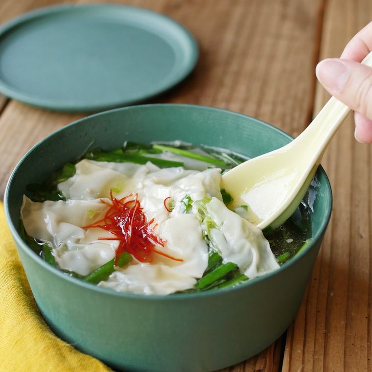 器に盛られた餃子風ワンタンスープを、スプーンですくっている様子