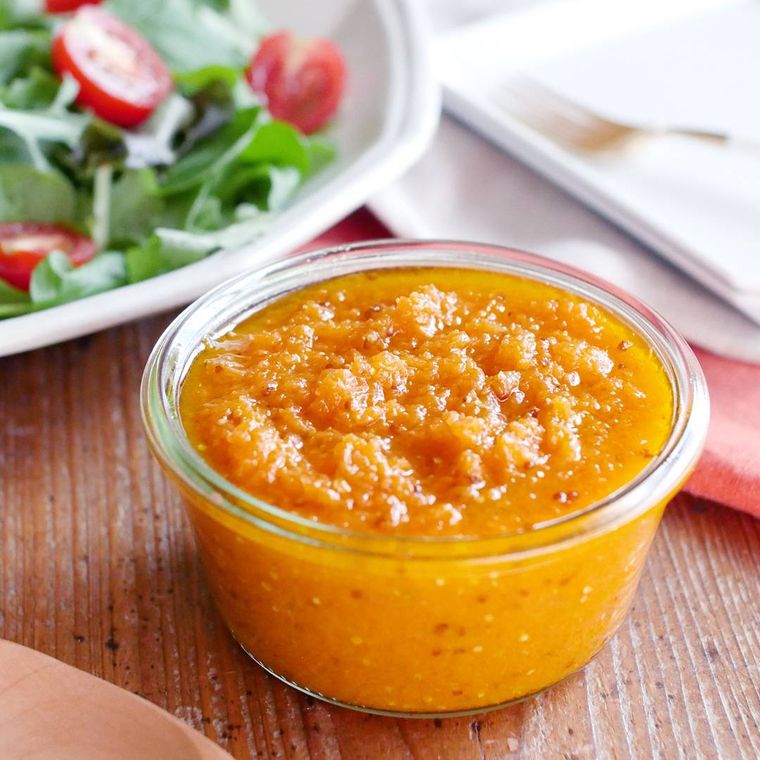 木のテーブルに置かれた器に入ったすりおろしにんじんドレッシング