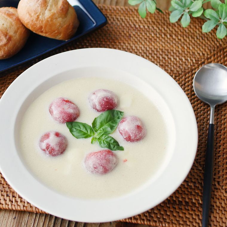 白いスープ皿によそったミニトマトとモッツァレラの豆乳ポタージュ