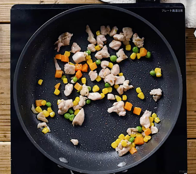 フライパンで鶏肉とミックスベジタブルを炒めている様子