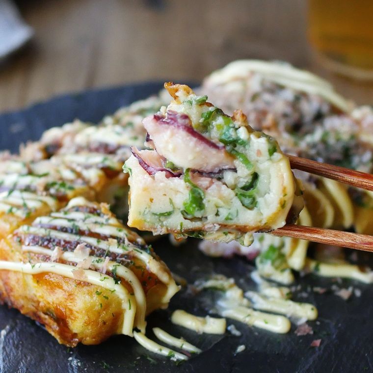 皿に盛られたぺったんたこ焼きを、箸でつまんでいる様子