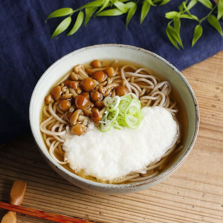 丼鉢になめことろろそばが盛り付けられている
