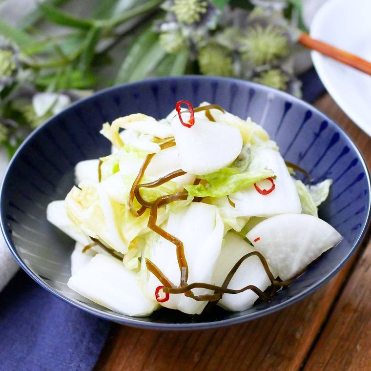 青い小鉢に盛りつけられている大根と白菜の塩こんぶ入り浅漬け